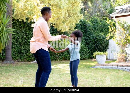 Femme afro-américaine de haut niveau qui passe du temps avec sa petite-fille dans leur jardin Banque D'Images