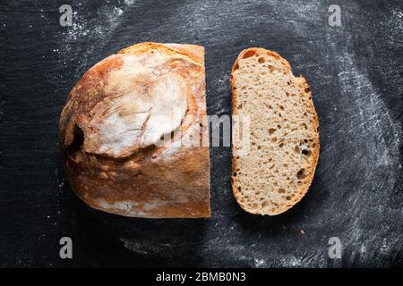 Ambiance sombre et ton maison cuisine maison biologique rustique Sourdough pain sur fond noir avec espace de copie Banque D'Images