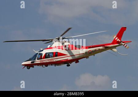 L'hélicoptère de chasse-feu AgustaWestland AW109 E Power Elite (VF-80) en vol à Malpensa (MXP / LIMC), Milan, Italie Banque D'Images