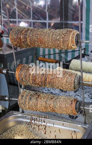 Kurtos kalacs ou des gâteaux de cheminée, la préparation de la cuisine sur le charbon de bois, la rue de cuisine traditionnelle hongroise, pendant le festival de la nourriture. Kurtos Kalacs traditiona Banque D'Images