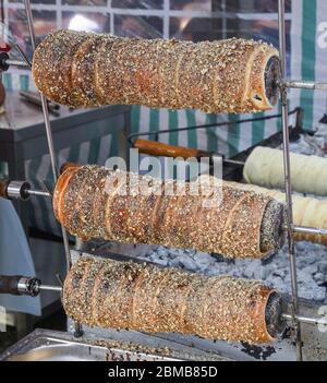 Kurtos kalacs ou des gâteaux de cheminée, la préparation de la cuisine sur le charbon de bois, la rue de cuisine traditionnelle hongroise, pendant le festival de la nourriture. Kurtos Kalacs traditiona Banque D'Images