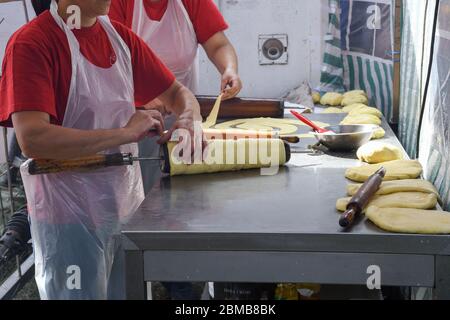 Kurtos kalacs ou des gâteaux de cheminée, la préparation de la cuisine sur le charbon de bois, la rue de cuisine traditionnelle hongroise, pendant le festival de la nourriture. Kurtos Kalacs traditiona Banque D'Images