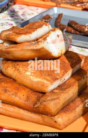 Spécialité roumaine traditionnelle du ventre de porc salé appelée slanina, sur le comptoir pendant le marché agricole ou la foire de campagne Banque D'Images