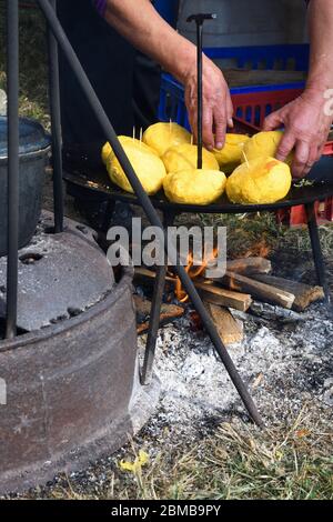 Boules de polenta et fromage au milieu de lui, appelé bulz, un plat traditionnel roumain. Rôtir la polenta et le fromage sur un grill extérieur, avec des moutons s Banque D'Images