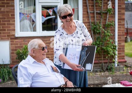 Plus, Cambridgeshire, Royaume-Uni. 8 mai 2020. Cyril Cook, ancien combattant de la Seconde Guerre mondiale, aime une fête dans son jardin à la maison pour célébrer le 75e anniversaire de la Journée mondiale. Âgé de 98 ans, il a été un soldat du Royal Electrical and Mechanical Engineers. Il a reçu une peste et un certificat de la branche locale de la Légion britannique et a été rejoint par des membres de sa famille. Crédit : Julian Eales/Alay Live News Banque D'Images