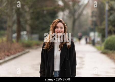 Belle jeune femme avec des cheveux de Chestnut Brown souriant à Park Banque D'Images