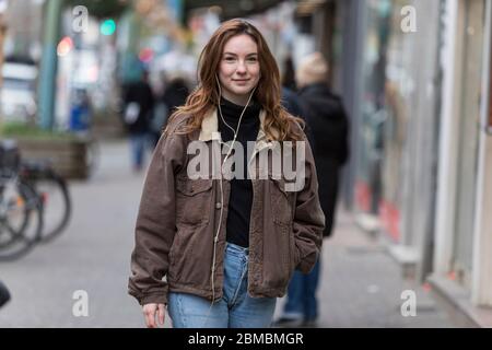 Jeune femme marchant et souriant à Camera Banque D'Images