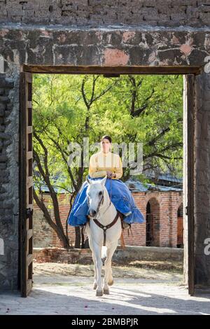 Paulina Pedrero passe par une porte à Hacienda la Cantera à Lagos de Moreno, Jalisco, Mexique. Banque D'Images