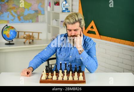 Figures sur le plateau d'échecs. Passe-temps intellectuel. Réfléchir à l'étape suivante. Faites votre propre pensée de manière indépendante. Leçon d'échecs. Concept de stratégie. Enseignant d'école. Jeu de société. Homme intelligent jouant aux échecs. Banque D'Images