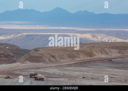 Les montagnes lointaines déversent des camions au premier plan du paysage de la mine de strip Banque D'Images