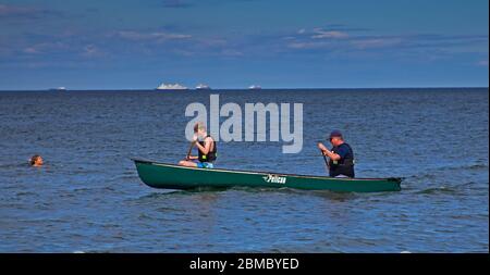 Portobello, Édimbourg, Écosse, Royaume-Uni. 8 mai 2020. Gordon et Lindsay avaient assez de place dans leur bateau à rames pour aller à distance sociale lorsqu'ils passent devant une femme qui nage, mais ils sont du même foyer. Banque D'Images