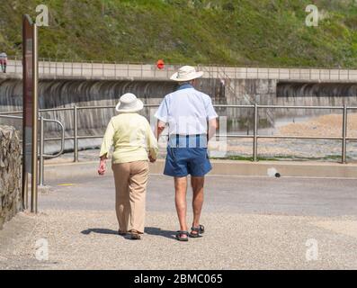 Lyme Regis Dorset, Royaume-Uni. 8 mai 2020. Météo au Royaume-Uni: Un chaud et ensoleillé après-midi de vacances en banque à Lyme Regis, West Dorset. Une promenade en couple le long du front de mer vers Charmouth. Crédit : Celia McMahon/Alay Live News. Banque D'Images