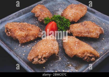 Aile de poulet croustillante frite en tebasaki de style japonais avec dorsgroung foncé. Banque D'Images