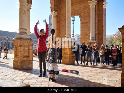 Séville, Espagne: 23 décembre 2019: Les touristes apprécient le spectacle traditionnel de flamenco de rue, spectacle pour les visiteurs à la Plaza de Espana. Attraction et divertissement Banque D'Images