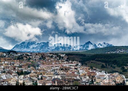 Belle vue d'hiver sur une montagne enneigée. Nuages de neige sur un village dans les montagnes enneigées de la Sierra Nevada d'Espagne. Banque D'Images