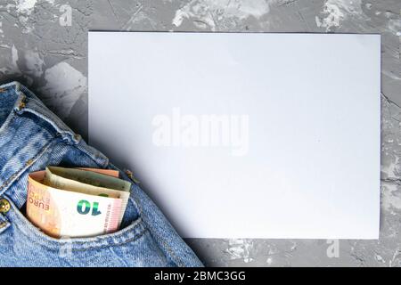 Poche argent en Blue Jeans avec passeport - EURO et feuille de papier blanche pour les notes sur fond gris Banque D'Images