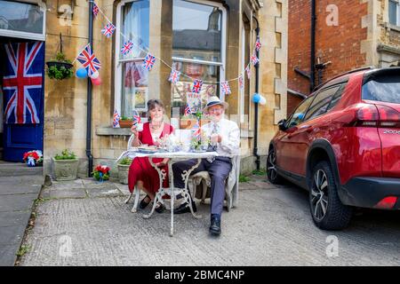 Chippenham, Wiltshire, Royaume-Uni, 8 mai 2020. Un couple est photographié prendre le thé de l'après-midi dans son jardin à l'avant, en commémoration du 75e anniversaire de la Ve journée . Credit: Lynchpics/Alay Live News Banque D'Images