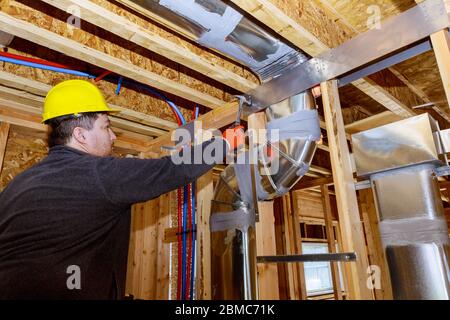 Les travailleurs qui font des conduits finaux de climatisation système HVAC les tuyaux de ventilation sont des supports de chauffage Banque D'Images