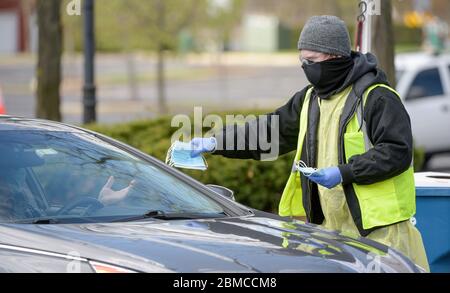 Schaumburg, Illinois, États-Unis. 8 mai 2020. Austin MEYER, employé du village de Schaumburg, distribue gratuitement des masques aux résidents de la banlieue de Chicago, Illinois, lors d'un événement de distribution de masques gratuit le vendredi 8 mai 2020. Le village avait prévu de distribuer environ 70,000 masques pendant l'événement de trois jours. À compter du 1er mai, toutes les personnes de plus de 2 ans dans l'Illinois doivent porter un masque ou une couverture faciale en public ou au travail lorsque la distance sociale de 6 pieds est impossible ou impossible. Le village de banlieue a une population d'environ 158,000 000 habitants. Crédit : ZUMA Press, Inc./Alay Live News Banque D'Images