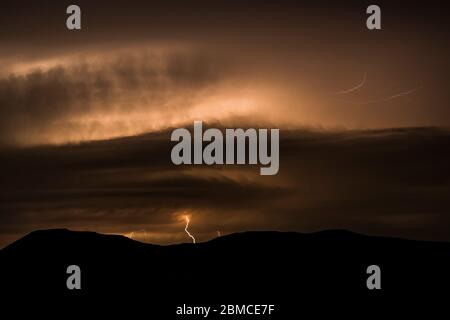 Orage nocturne intense avec un éclair de nuages à terre et à haute intensité au-dessus de la vallée de Mimbres et des montagnes environnantes, vue de la ville de RO Banque D'Images