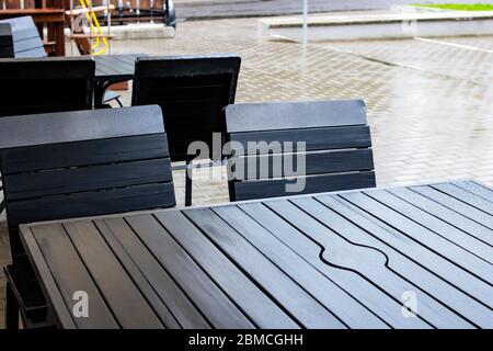 Table et chaises de rue mouillées sous la pluie Banque D'Images