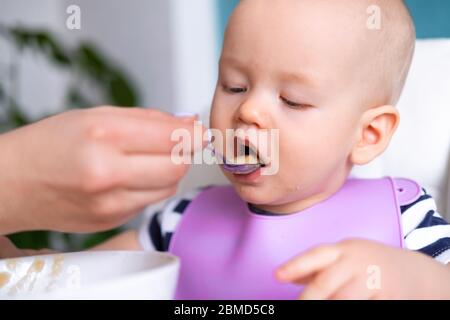 nourriture pour bébé. Maman nourrit petit enfant caucasien. Porridge sain, mains de mère avec cuillère. Nouveau-nés, enfants Banque D'Images