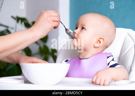 nourriture pour bébé. Maman nourrit petit enfant caucasien. Porridge sain, mains de mère avec cuillère. Nouveau-nés, enfants Banque D'Images