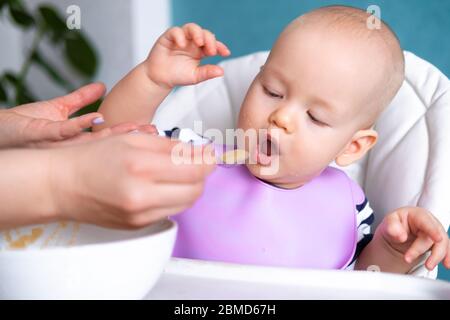 nourriture pour bébé. Maman nourrit petit enfant caucasien. Porridge sain, mains de mère avec cuillère. Nouveau-nés, enfants Banque D'Images