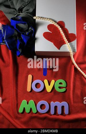 Lettres colorées avec ma maman d'amour isolée sur fond rouge de tissu. J'aime maman orthographié avec des lettres colorées et coeur rouge pour la fête des mères. Banque D'Images