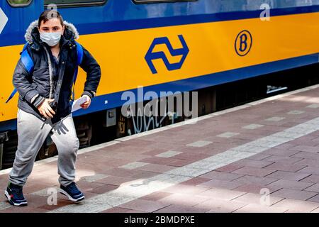 Rotterdam, pays-Bas. 07th Mai 2020. Un enfant quitte le train tout en portant un masque facial par mesure de précaution contre la propagation du virus corona.à compter du 1er juin, le port de masques faciaux sera une obligation pour le public d'accéder aux plates-formes de la gare centrale, les bus publics et les métros comme mesure préventive pendant la crise covid 19. Crédit : SOPA Images Limited/Alamy Live News Banque D'Images