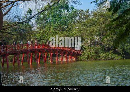 Hanoï Vietnam octobre 25 2013 ; touristes et habitants traversant le pont Huc rouge traditionnel de style oriental au-dessus du lac Hoan Kiem dans le parc de la ville. Banque D'Images