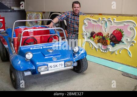 28 avril 2020, Bavière, Burgthann : le showman Johannes Braun s'agenouille dans son atelier entre un véhicule restauré d'un carrousel pour enfants et un panneau nouvellement peint d'un stand de bonbons. Il a été habitué à être un showman depuis qu'il était un enfant. Braun dirige l'entreprise familiale de la 7e génération avec sa mère. En fait, Johannes Braun et sa famille sont sur la route depuis des mois. Avec des voitures tamponneuses et un carrousel pour enfants, ils voyagent de la foire à la foire. Mais à cause de la crise corona Braun ne peut pas travailler pour le moment et craint maintenant pour son existence. (À dpa, « réparations et friandises sont à l'intérieur Banque D'Images