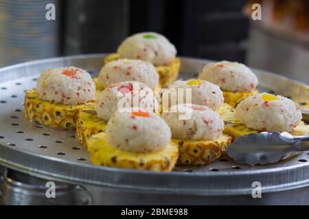 Dessert chinois, boules de riz vapeur sur des tranches d'ananas frais Banque D'Images