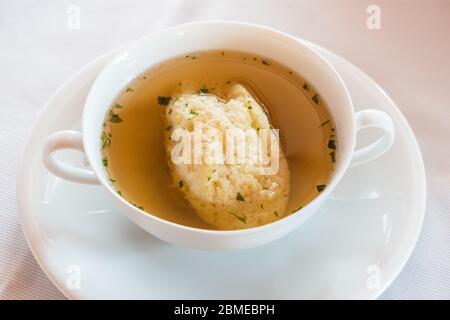 Soupe de boulettes de semoule, bouillon de bœuf au persil dans une coupe de bouillon blanc, spécialité de la cuisine autrichienne et viennoise Banque D'Images