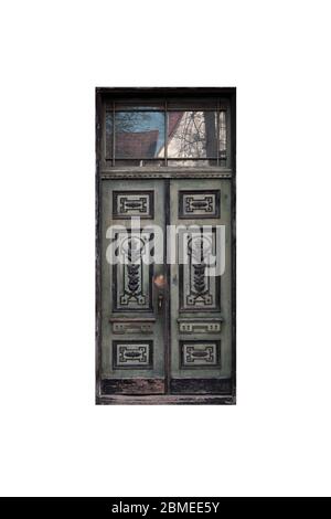 Porte en bois vert foncé avec décoration dans une façade de bâtiment ancien isolée sur fond blanc Banque D'Images