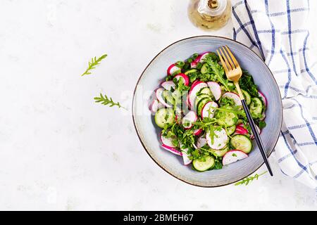 Salade végétarienne de radis, concombres, arugula et oignons verts. Nourriture végétalienne saine. Vue de dessus, au-dessus, à plat Banque D'Images