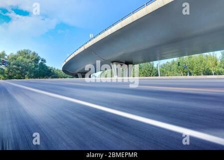 Sous le pont, route asphaltée sans voiture, gratte-ciel moderne de construction de ville comme arrière-plan. Banque D'Images