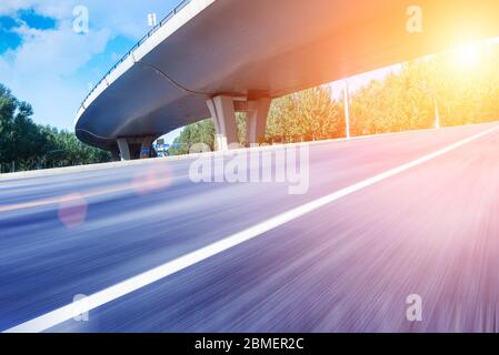 Sous le pont, route asphaltée sans voiture, gratte-ciel moderne de construction de ville comme arrière-plan. Banque D'Images