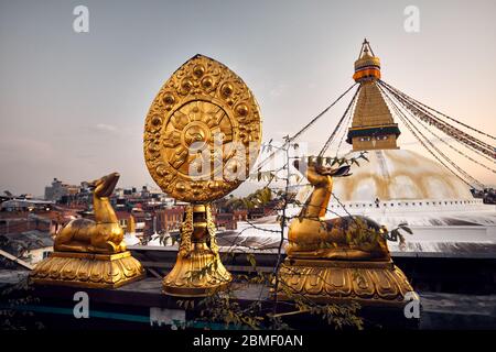 Statues de cerfs d'or avec feuille, à la toiture de l'abbaye et de Bodnath Stupa bouddhiste au Ciel de coucher du soleil à Katmandou Banque D'Images