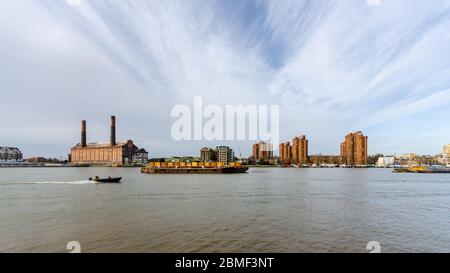 Londres, Angleterre, Royaume-Uni - 12 décembre 2013 : un hors-bord passe des barges à conteneurs amarrés à côté de la centrale électrique de lots Road et de la propriété World's End Estate dans le R Banque D'Images