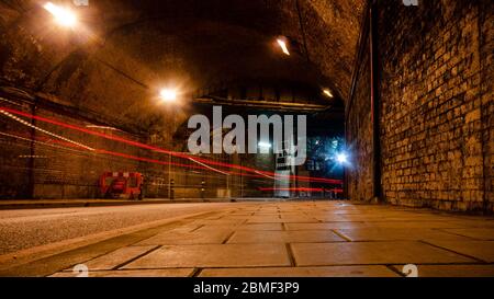 Londres, Angleterre, Royaume-Uni - 28 novembre 2013 : la circulation laisse des sentiers de lumière la nuit sur Crucifix Lane sous le viaduc d'arche de brique de London Bridge Railway S. Banque D'Images