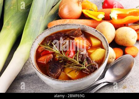 Ragoût de viande avec légumes. Ragoût de bœuf avec pommes de terre, carottes et herbes sur la table. Banque D'Images