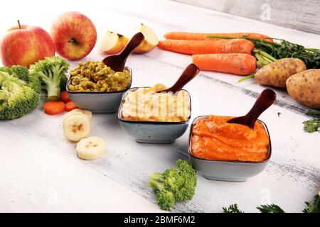 Bols avec nourriture pour bébé. Purée de bébé verte, jaune et orange avec légumes frais biologiques Banque D'Images