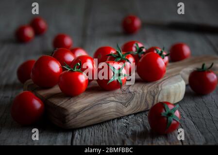 Tomates cerises biologiques mûres fraîches sur fond de bois foncé Banque D'Images