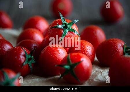 Tomates cerises biologiques mûres fraîches sur fond de bois foncé Banque D'Images
