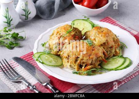 Côtelettes de bœuf avec pommes de terre servies avec des microgrines de concombre et de pois sur une plaque blanche sur fond de béton gris, gros plan, format horizontal Banque D'Images