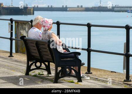 Weymouth, Dorset, Royaume-Uni. 9 mai 2020. Météo au Royaume-Uni : les gens assis à côté du port lors d'une journée de soleil brûlant à la station balnéaire de Weymouth à Dorset pendant le confinement du coronavirus. Crédit photo : Graham Hunt/Alay Live News Banque D'Images