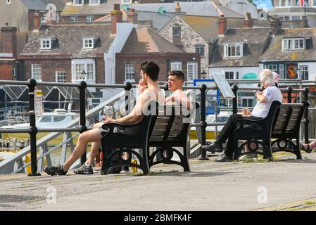 Weymouth, Dorset, Royaume-Uni. 9 mai 2020. Météo au Royaume-Uni : les gens assis à côté du port lors d'une journée de soleil brûlant à la station balnéaire de Weymouth à Dorset pendant le confinement du coronavirus. Crédit photo : Graham Hunt/Alay Live News Banque D'Images