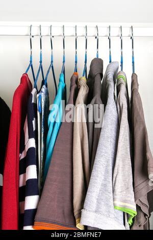 Vêtements pour hommes et pour femmes sur cintres en silicone dans le placard de la penderie. Les mêmes épaules. Organisation du stockage. Ordre et propreté. Quarantaine, se Banque D'Images