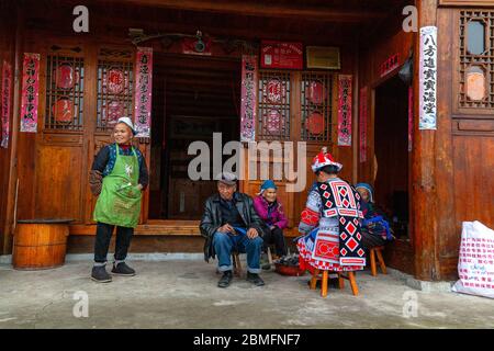 Famille à l'extérieur de leur maison (affectée pour les touristes). Ils sont de la minorité Gejia. Village de Matang, région de Kaili, province de Guizhou, Chine Banque D'Images